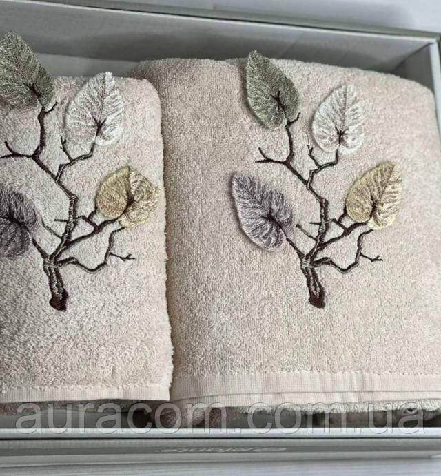 Комплект з двох махрових рушників (70x140 см) бежевого кольору з об'ємною вишивкою гілок і листя.
