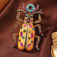 Брошка на золотистій основі великого жук з різнобарвними кристалами покрита кольоровою емаллю розмір 75х45 мм