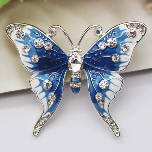Брошка на сріблястій основі метелик із білими кристалами покрита кольоровою емаллю розмір 50х45 мм