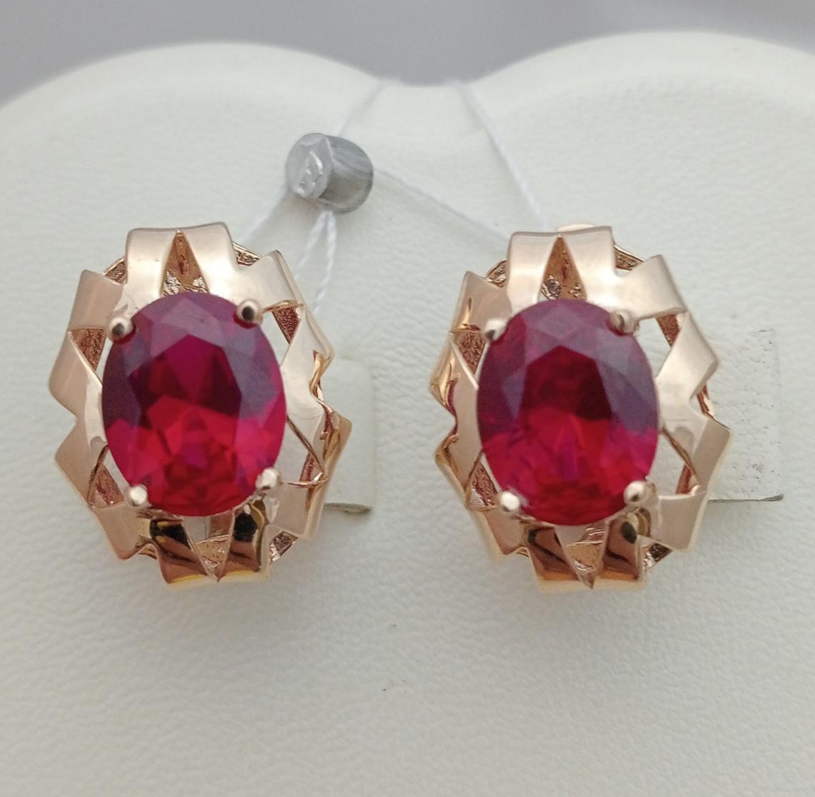 Золоті сережки з великим червоним каменем.