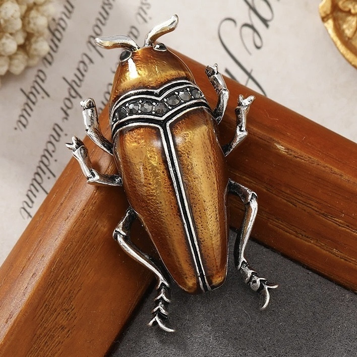 Брошка металева на сріблястій основі жук із чорними кристалами покрита кольоровою емаллю розмір 50х30 мм