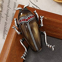 Брошка металева на сріблястій основі жук із червоними стразами покрита кольоровою емаллю розмір 50х30 мм