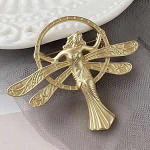 Брошка металева на золотистій основі хрещата фея в платті покрита золотистою емаллю розмір 45х50 мм