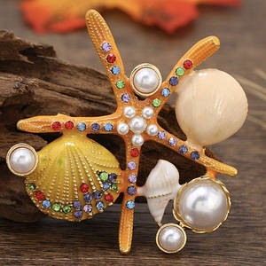 Брошка металева на золотистій основі морська зірка з перлами та мушлями розмір виробу 60х60 мм