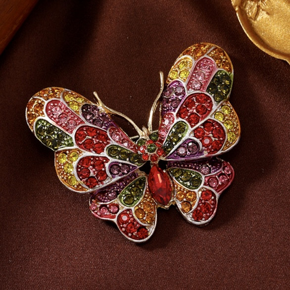 Брошка на золотистій основі великий метелик із різнобарвними камінчиками, що переливаються, розмір 50х45 мм