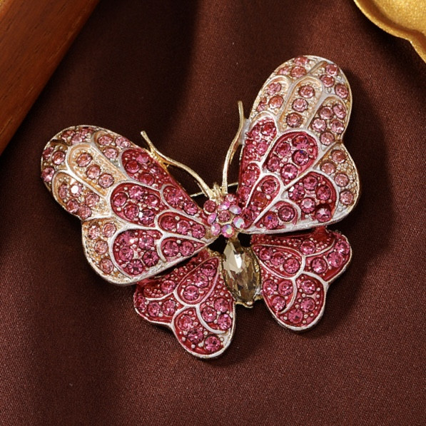Брошка на золотистій основі — великий метелик із рожевими стразами, що переливаються, розмір 50х45 мм