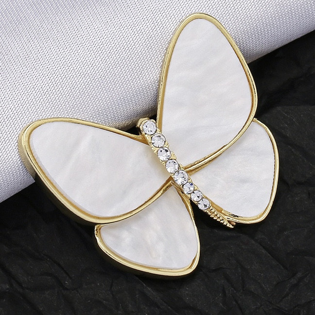 Брошка на золотистій основі метелик із білими мерехтливими крильцями та білими стразами розмір 45х40 мм