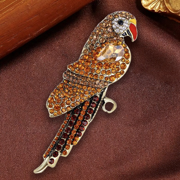 Брошка металева на золотистій основі папуг із жовтими та жовтими кристалами розмір 95х35 мм