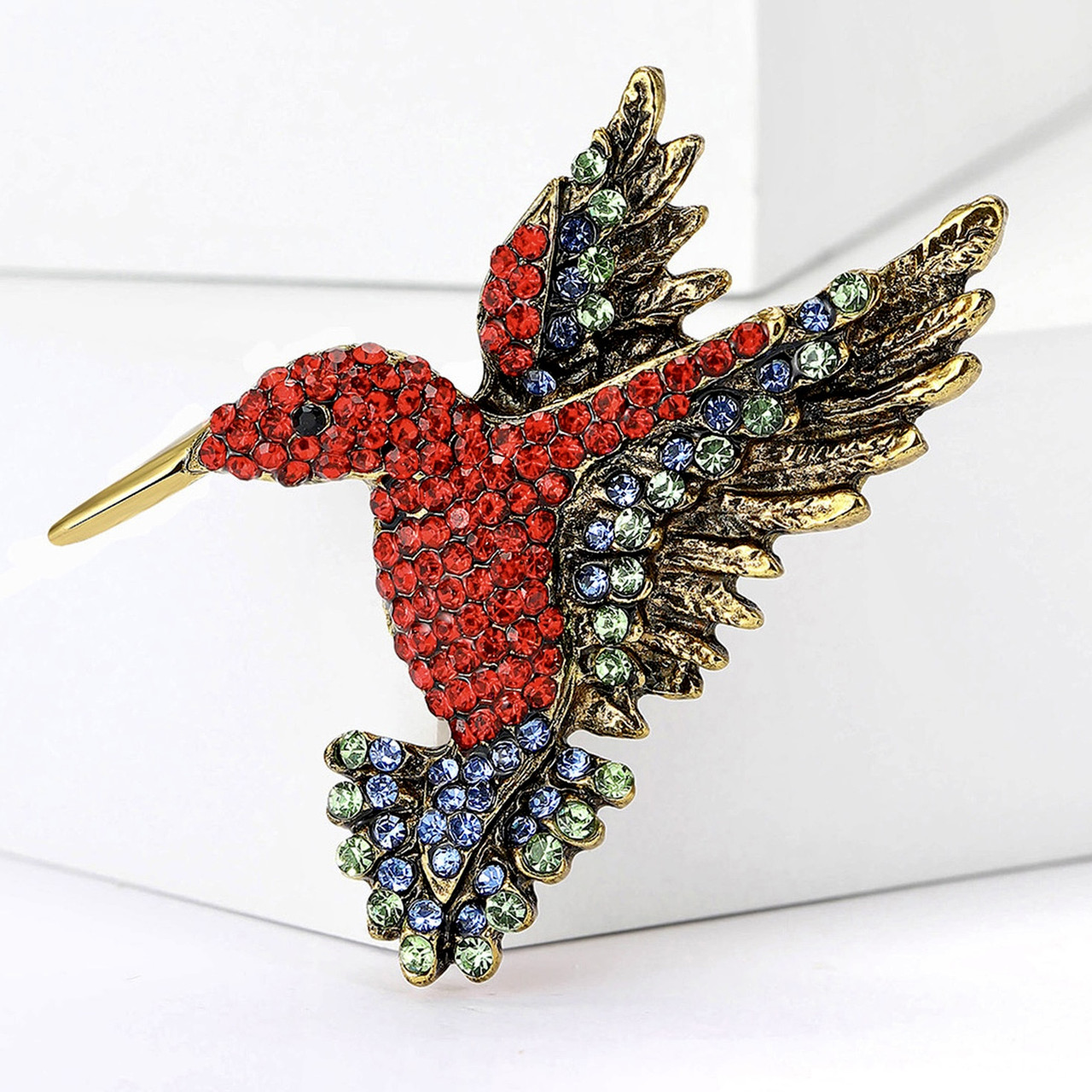 Брошка металева на сріблястій основі колібрі з різнобарвними камінцями розмір 50х55 мм