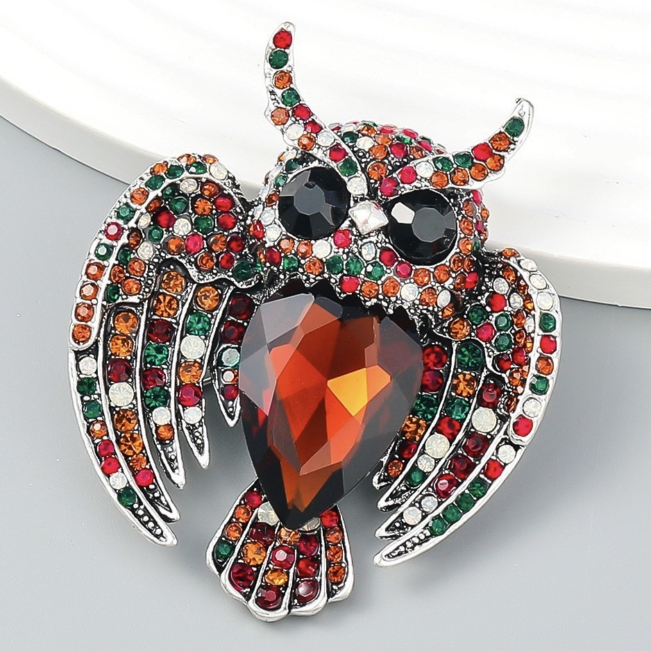Брошка металева на сріблястій основі сова з різнобарвними стразами, що переливаються, розмір 65х55 мм