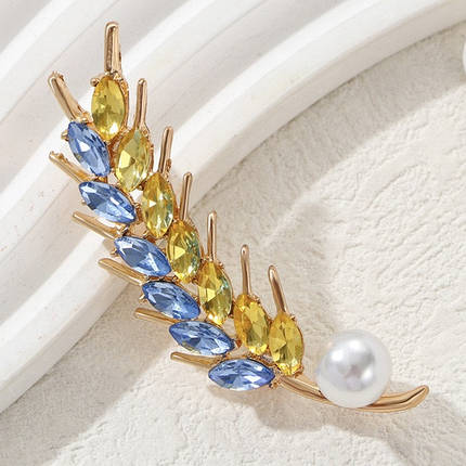 Брошка на золотистій основі колосок із блакитними та жовтими стразами та білою намистиною розмір виробу 65х20 мм, фото 1