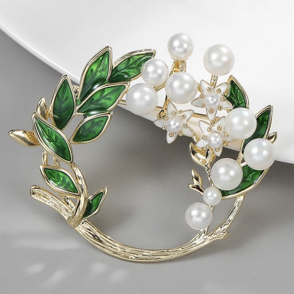 Брошка на золотистій основі віночок із листочками та квіточками з білими намистинами розмір виробу 45х45 мм