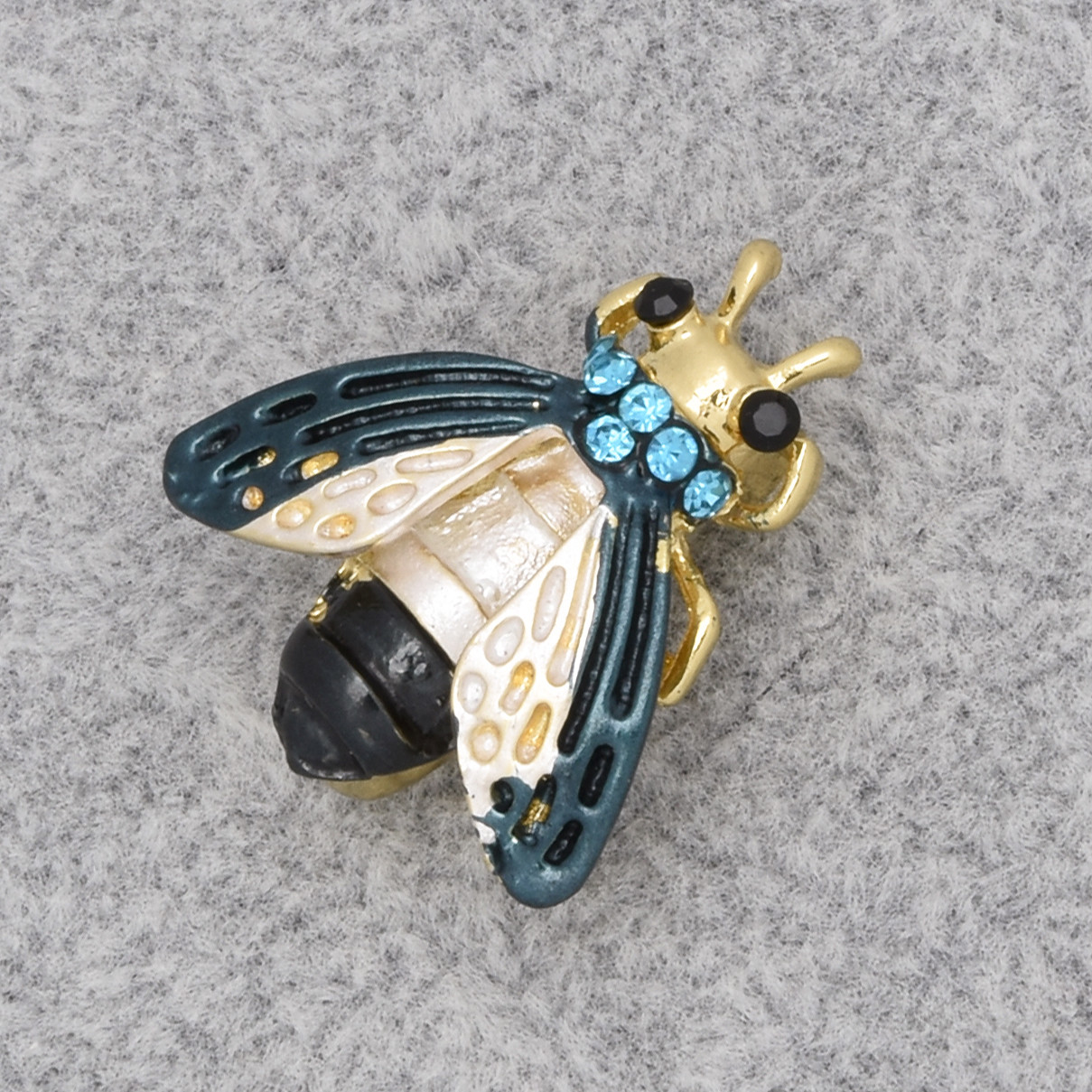Брошка на золотистій основі муха з блакитними стразами покрита кольоровою емаллю розміром 25х20 мм