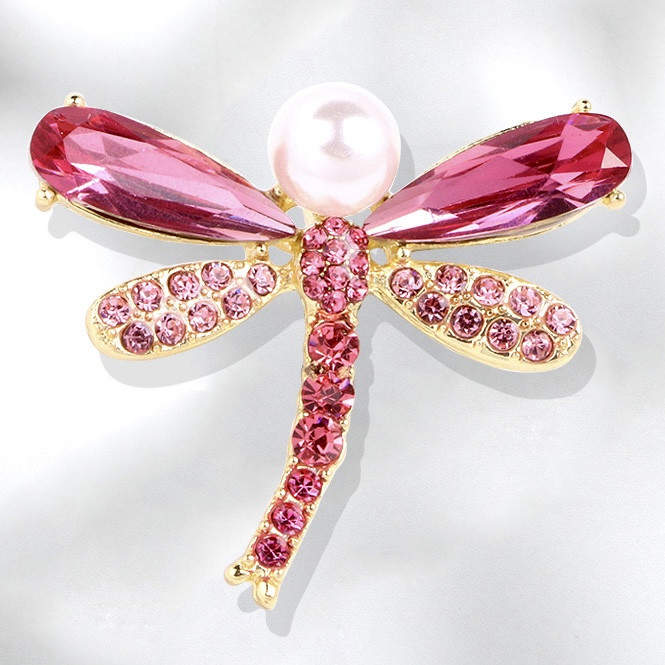 Брошка на золотистій основі бабка з різнобарвними рожевими стразами та білою намистиною виробу 35х35 мм
