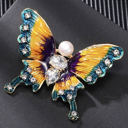 Брошка на золотистій основі метелик із білими стразами та намистиною покрита кольоровою емаллю розмір 50х40 мм, фото 2