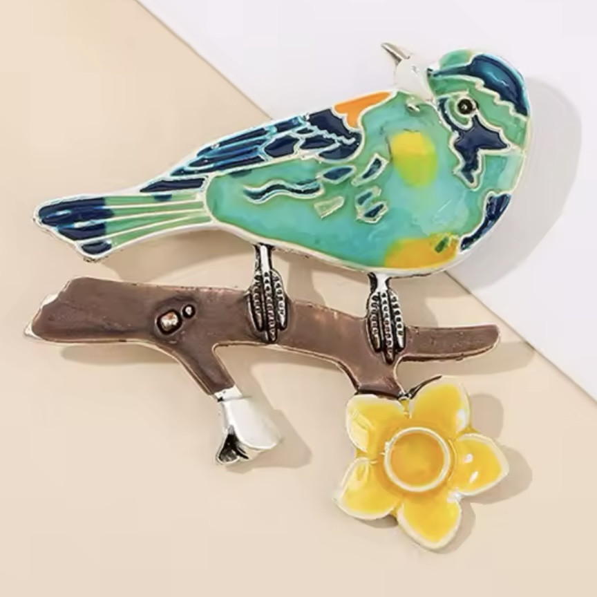 Брошка металева на сріблястій основі птах на гілочці з квіточкою покрита кольоровою емаллю розмір 50х50 мм