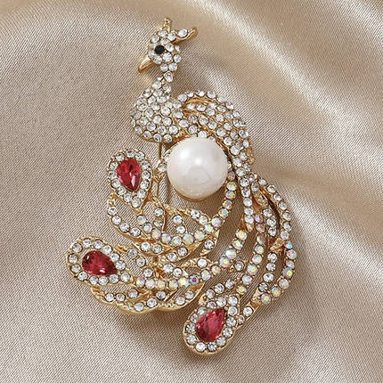 Брошка металева на золотистій основі птиця з білою намистиною й білими та рожевими стразами розмір 60х35 мм, фото 1