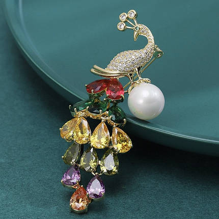 Брошка металева на золотистій основі павич із різнобарвними кристалами та намистиною розмір 75х20 мм, фото 1