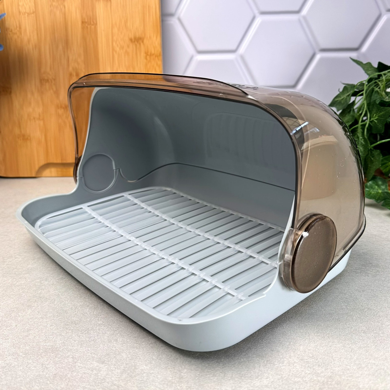 Невелика сіра пластикова хлібниця з відкидною кришкою