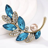 Брошка на золотистій основі гілочка з білими та бірюзовими кристалами та намистиною розмір виробу 45х20 мм