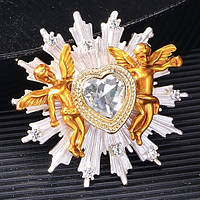 Брошка на золотистій сріблястій основі серце з білим кристалом і небом розмір виробу 40Х40 мм