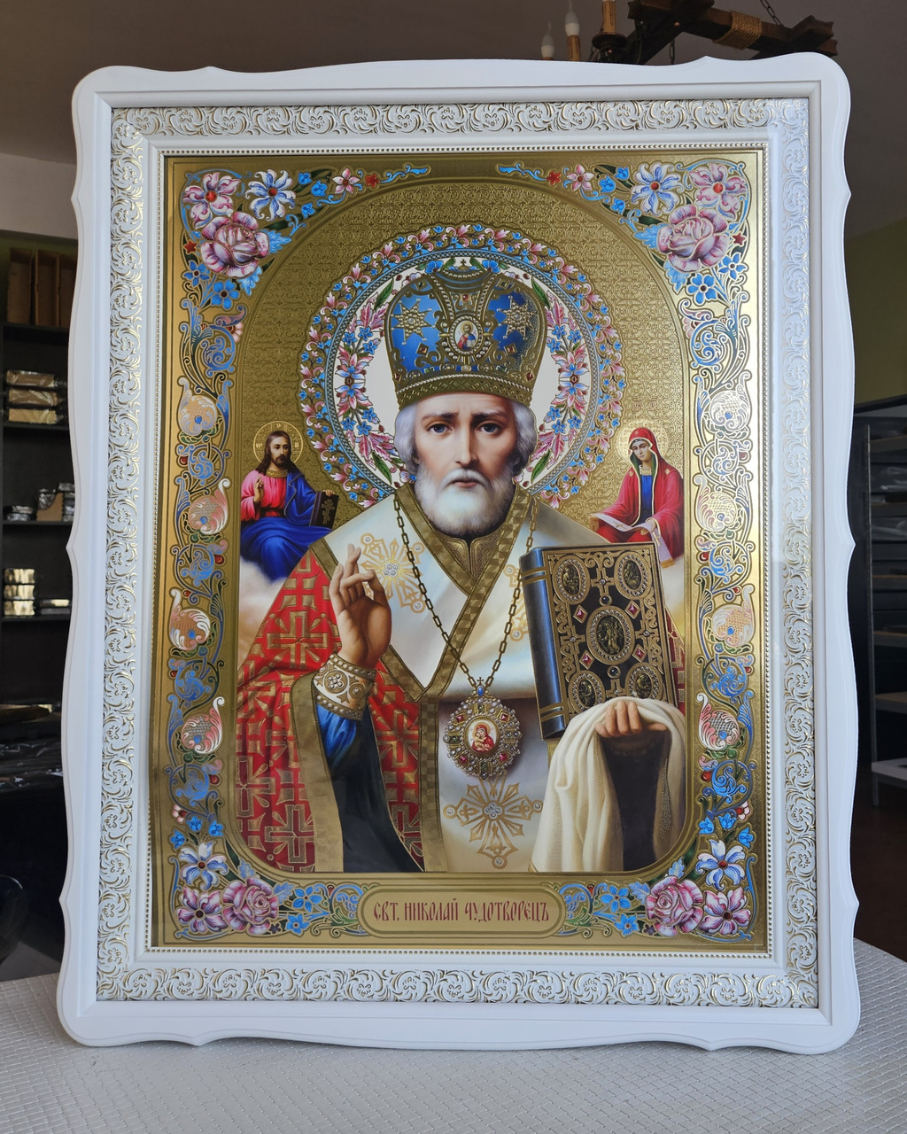 Ікона Святий Микола Чудотворець у білому дерев'яному кіоті під склом, розмір 77*61, сюже з квітами 65*48