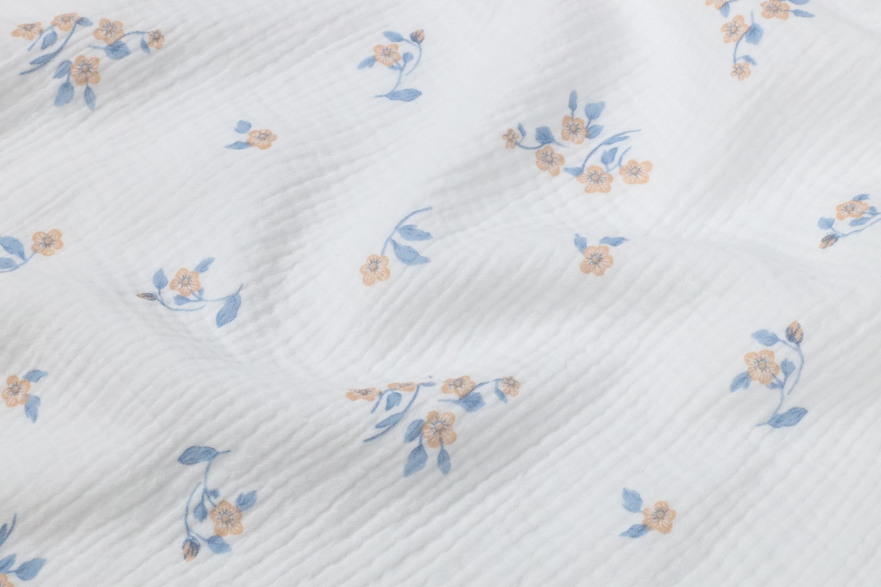 Муслін жатка Квіточки абрикосово-блакитні на білому 135 см