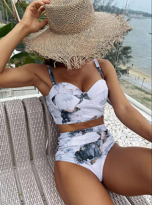 Жіночий купальник з високою посадкою чорних трусиків.