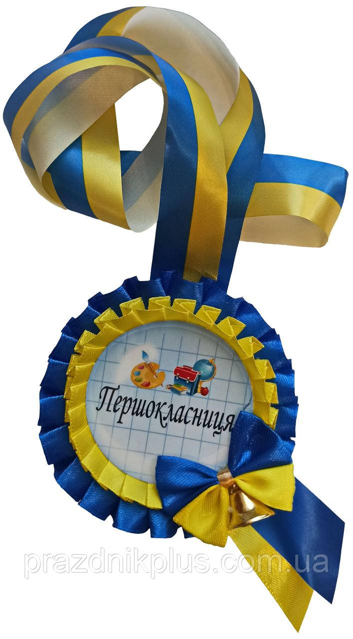 Жовто-синя медаль першокласниці з дзвіночком на стрічці