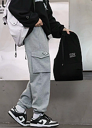 Модні спортивні штани в сірому кольорі з манжетами внизу та кишенями