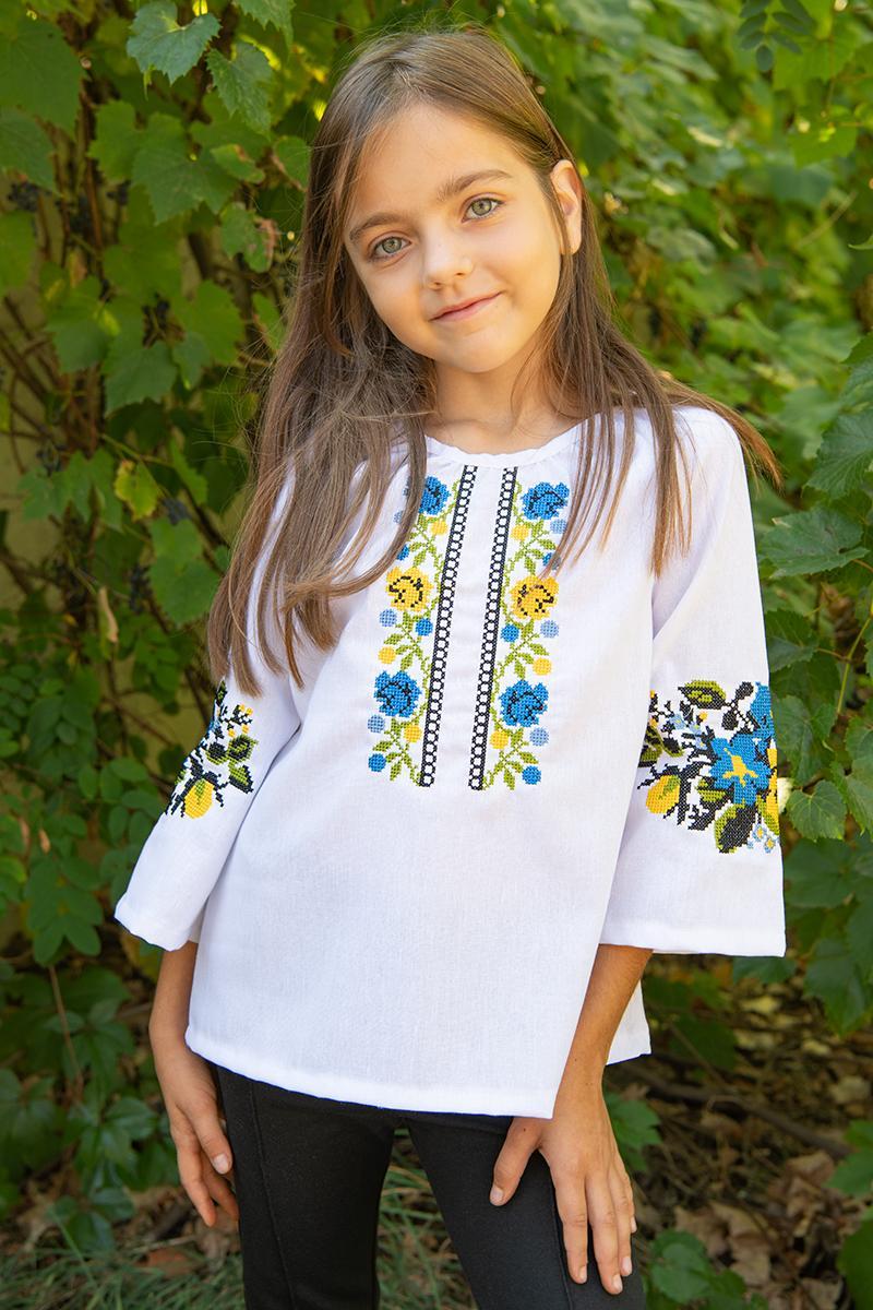 Біла вишита блуза для дівчинки з хрестиковою вишивкою у жовто-блакитних кольорах розміри 110–164