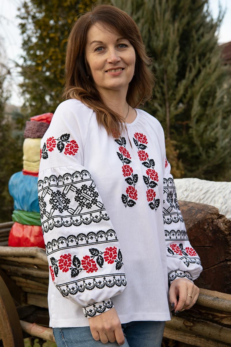 Жіноча вишиванка біла з червоно-чорними трояндами хрестиком і традиційним орнаментом на рукавах
