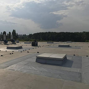 🔥 Сучасна технологія протипожежного захисту
На фото — приклад нового підходу до облаштування зон навколо люків димовидалення.
Замість важких бетонних плиток використовується негорюче полотно, яке:

не створює надмірного навантаження на утеплювач;