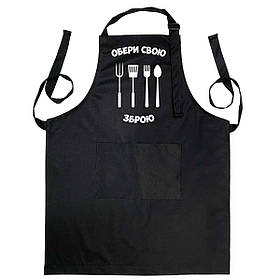Фартух чорного кольору з лямкою, що регулюється і кишенею "Обери свою зброю"
