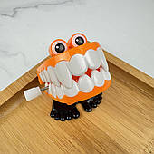 Іграшка у вигляді ходячих зубів з механізмом (оранжева з іклами), 1 шт