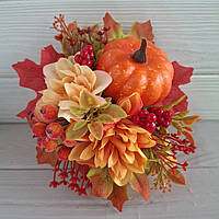 Осіння композиція з оранжевим гарбузом, квітами та ягодами.