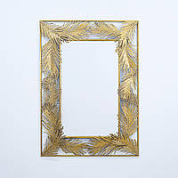 Настінне дзеркало зі скла і металу в рамі з листочками