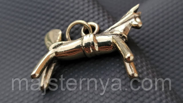 Детальний крупний план латунної підвіски «Сирний коник» — текстура, гравіювання, колір металу