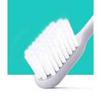 Зубна щітка середньої жорсткості антибактеріальна для догляду за зубами та яснами з унікальним дизайном щетинок.
