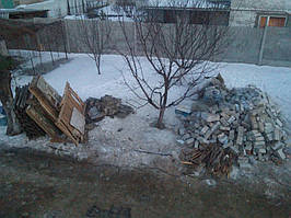 Отдельно сложенные деревянные части постройки и более или менее пригодные кирпичи.