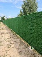 Паркан із штучної трави, встановлений навколо садової ділянки. Рішення створює ефект живої огорожі без додаткового догляду.