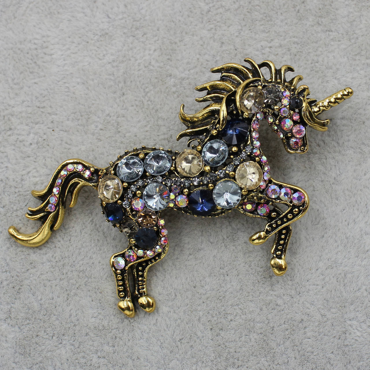 

Брошка металлическая крупная золотистая Единорог с разноцветными кристаллами размер изделия 90х50 мм