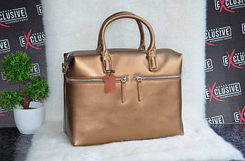 Золотиста жіноча шкіряна сумка з двома кишенями на блискавках.