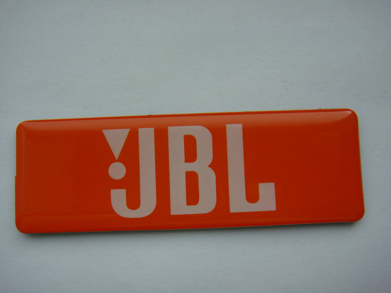 

Шильдик, наклейка, логотип (пластик) 77x25mm на сетку колонки JBL