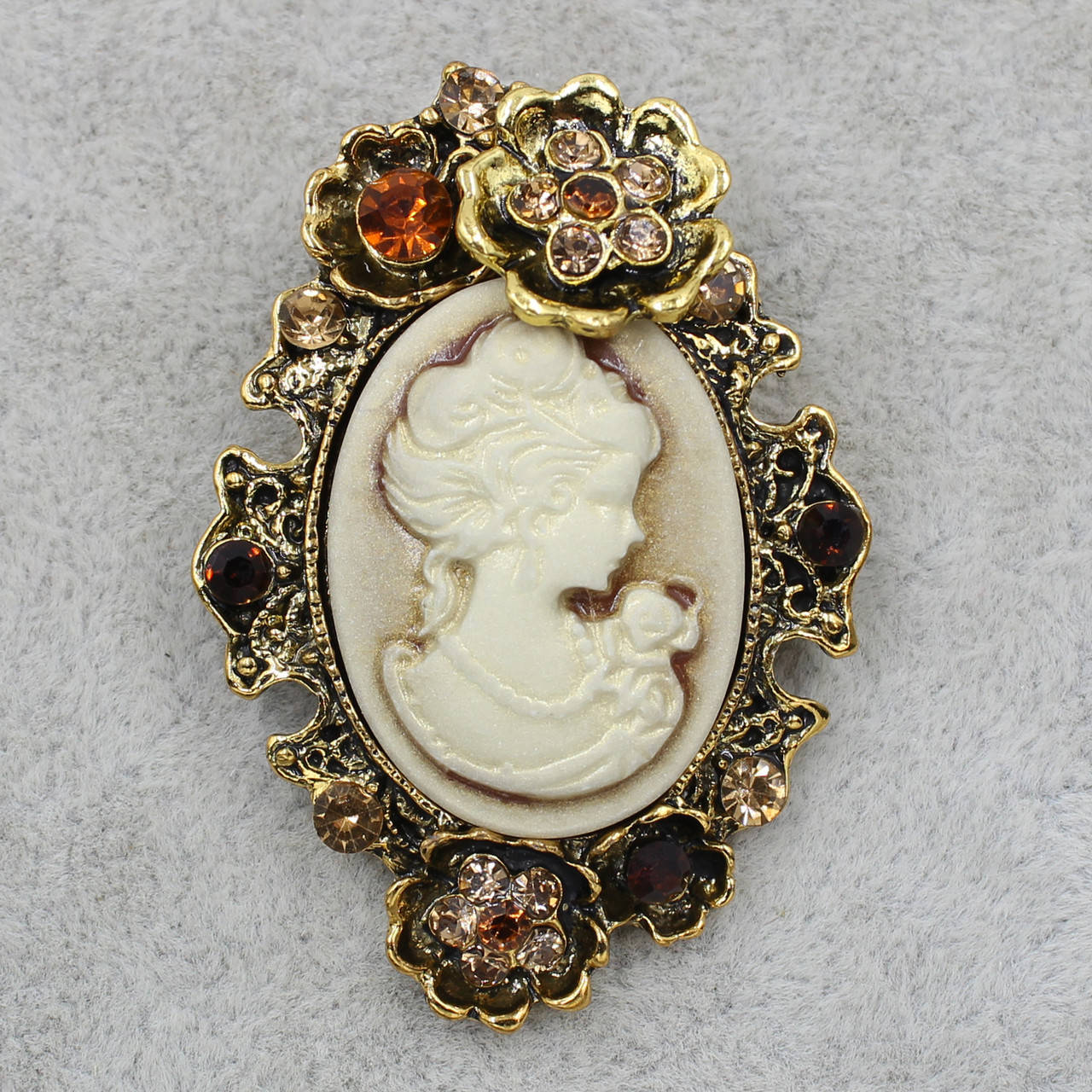 

Брошка металлическая золотистая Камея с цветочками с фианитами размер изделия 50х40 мм