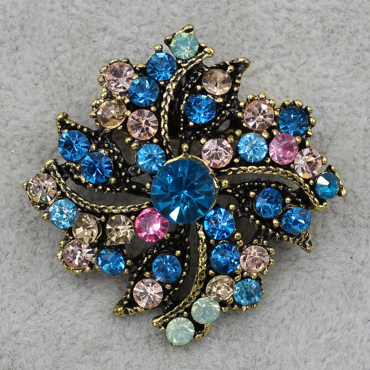 

Брошка металлическая золотистая с разноцветными фианитами размер изделия 40х40 мм