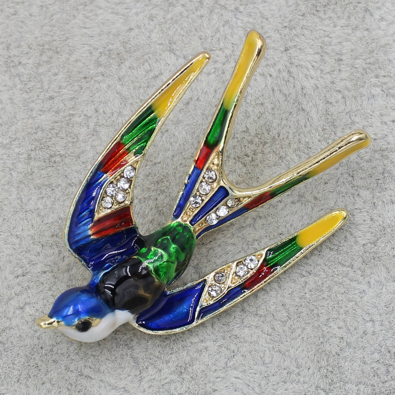 

Брошь металлическая золотистая Ласточка в стразах покрыта цветной эмалью размер изделия 40х30 мм