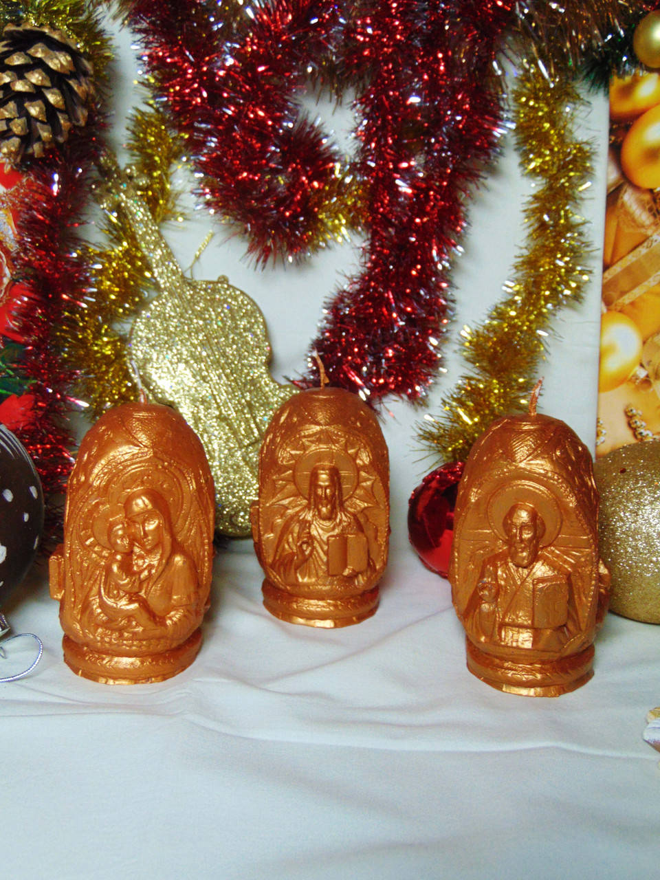 

Свеча "Три лика святых" золото