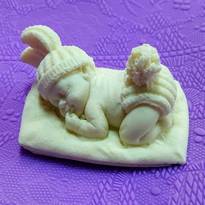 

Шоколадная фигурка младенец на подушке .