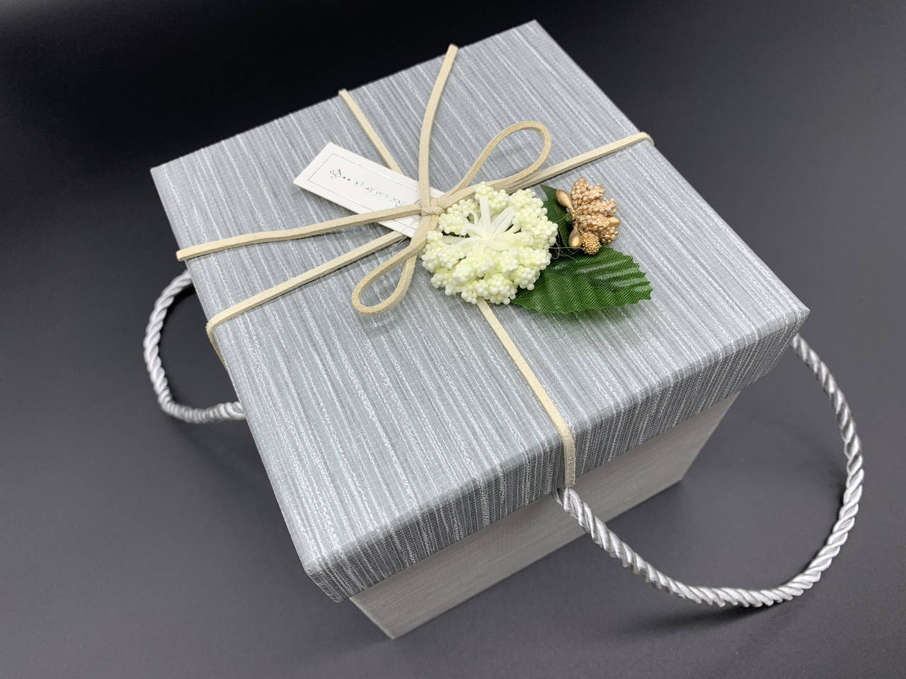 

Коробка подарочная с цветочком и ручками. Цвет "серебро". 13х13х13см.